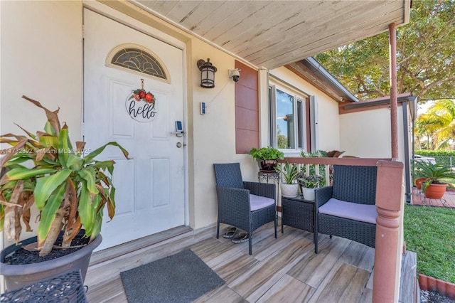 entrance to property featuring covered porch and stucco siding