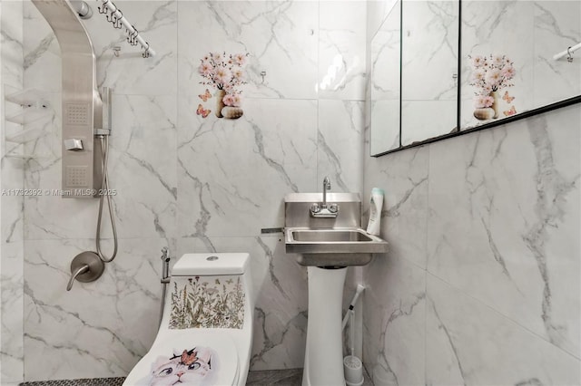 bathroom featuring a marble finish shower and toilet