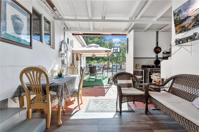 sunroom / solarium featuring beamed ceiling