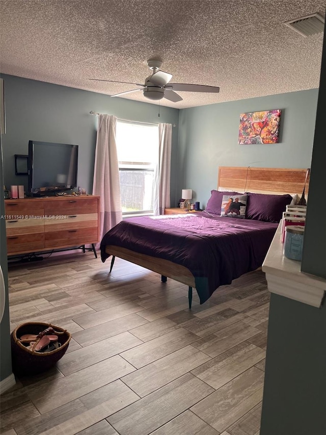 bedroom with a textured ceiling and ceiling fan