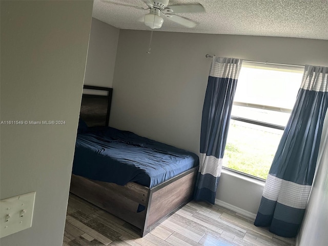 bedroom featuring multiple windows, a textured ceiling, and ceiling fan