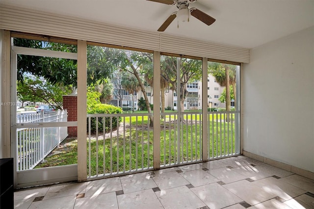 unfurnished sunroom with ceiling fan