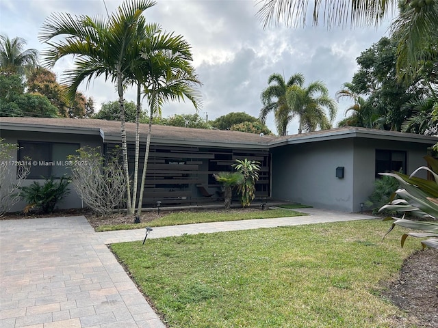 single story home featuring a front lawn