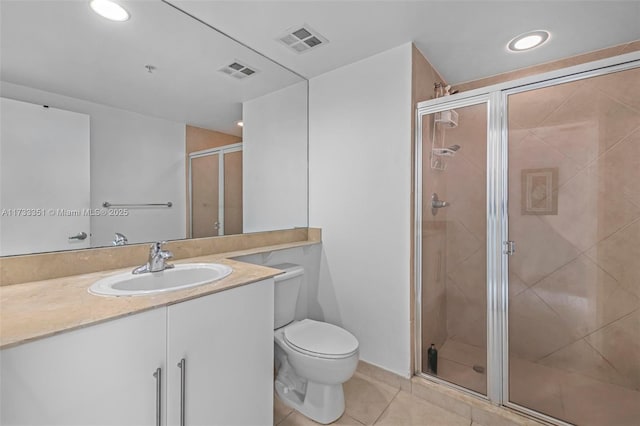 bathroom featuring toilet, vanity, tile patterned floors, and walk in shower