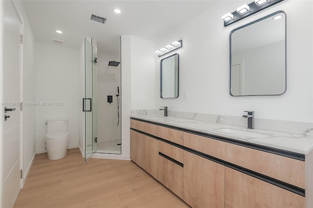 bathroom featuring vanity, an enclosed shower, hardwood / wood-style flooring, and toilet