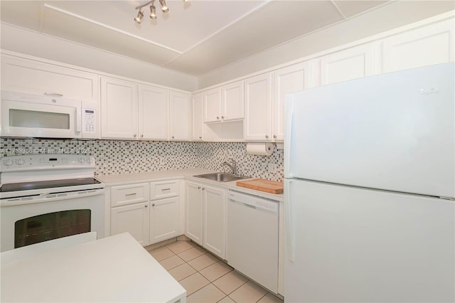 kitchen with sink, white appliances, light tile patterned floors, white cabinets, and decorative backsplash