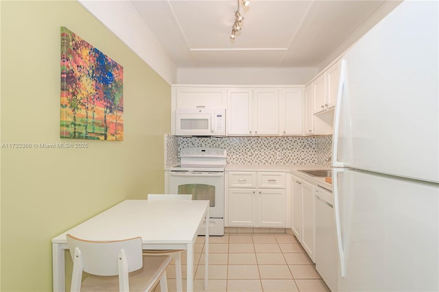 kitchen featuring light tile patterned flooring, sink, tasteful backsplash, white appliances, and white cabinets