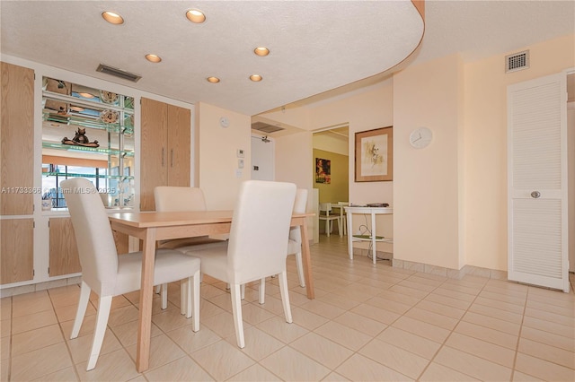 dining space featuring light tile patterned floors and a textured ceiling