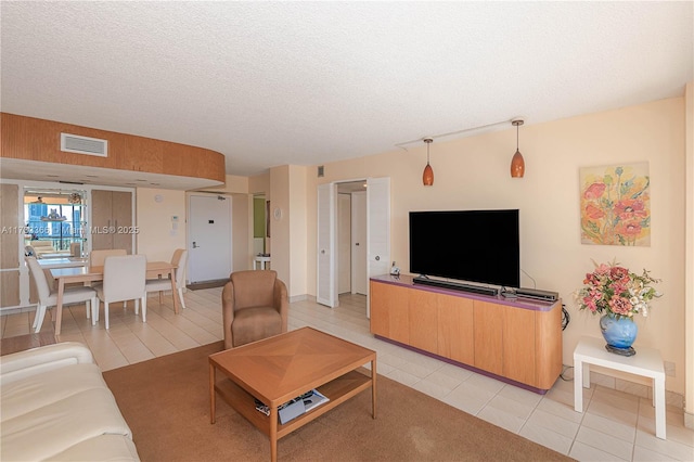 living room with light tile patterned flooring and a textured ceiling