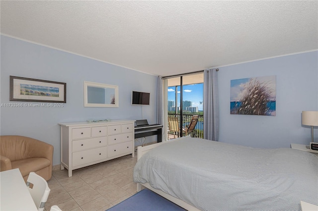 bedroom featuring expansive windows, access to exterior, a textured ceiling, and light tile patterned floors