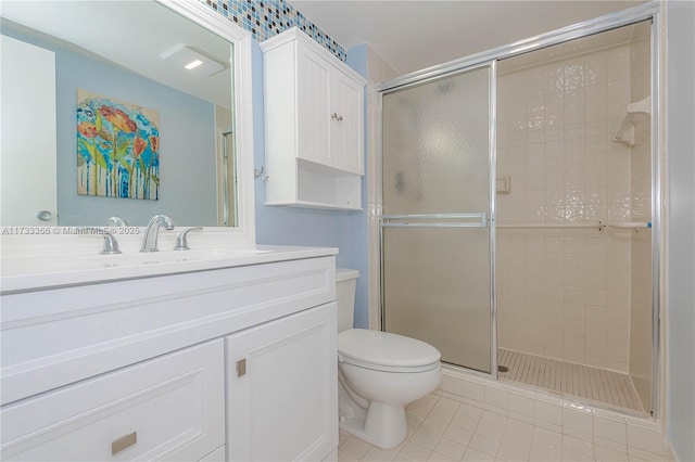 bathroom featuring vanity, toilet, tile patterned flooring, and a shower with door