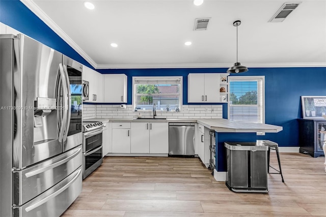 kitchen featuring appliances with stainless steel finishes, visible vents, a sink, and ornamental molding