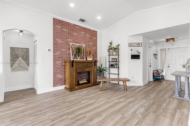 living area featuring crown molding, visible vents, and vaulted ceiling