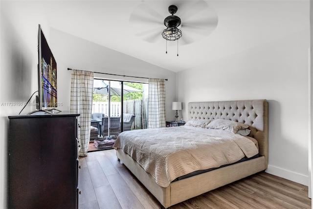 bedroom with wood finished floors, a ceiling fan, baseboards, vaulted ceiling, and access to outside