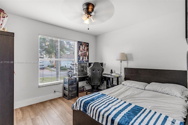 bedroom with a ceiling fan, baseboards, and wood finished floors