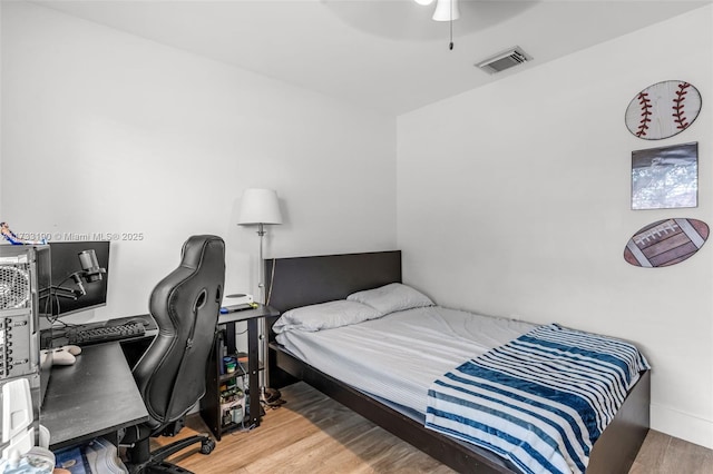 bedroom with visible vents, ceiling fan, and wood finished floors