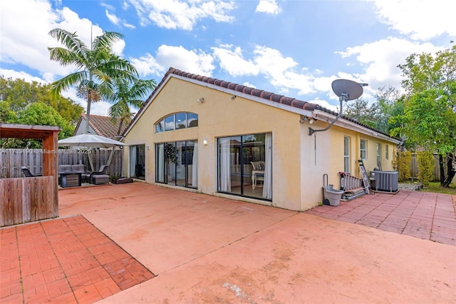 back of property featuring central AC unit, a patio area, fence, and stucco siding