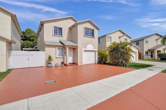 traditional-style house featuring a garage, fence, concrete driveway, a residential view, and stucco siding