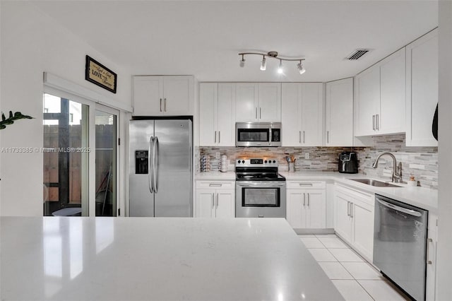 kitchen with white cabinets, stainless steel appliances, and light countertops