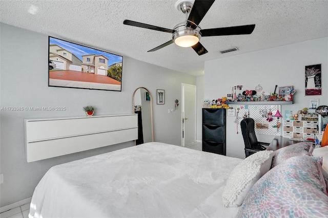 bedroom with a textured ceiling, visible vents, and a ceiling fan