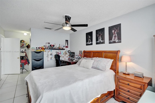 bedroom with visible vents, ceiling fan, a textured ceiling, and light tile patterned floors