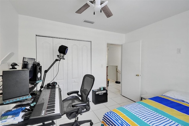 bedroom featuring a closet, visible vents, ceiling fan, and light tile patterned floors