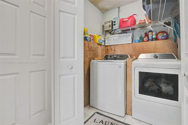 laundry room featuring laundry area, light tile patterned floors, and separate washer and dryer