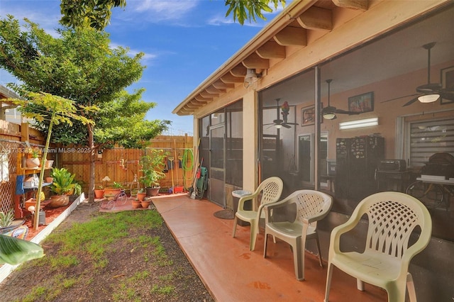 view of patio featuring ceiling fan and fence