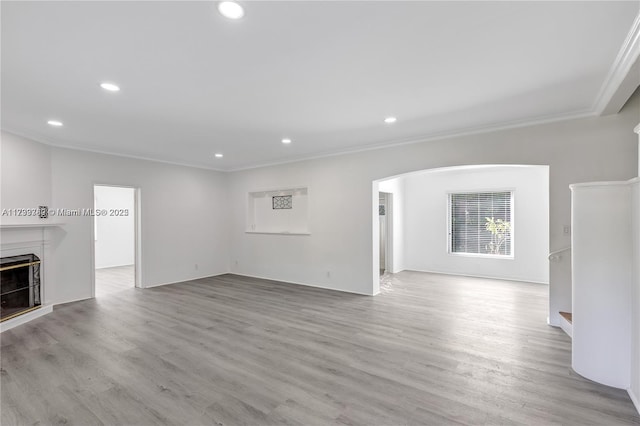 unfurnished living room featuring light hardwood / wood-style flooring and ornamental molding