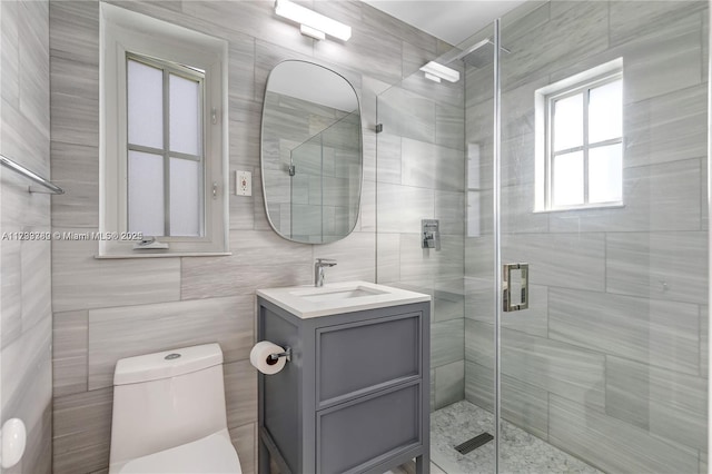 bathroom featuring an enclosed shower, vanity, tile walls, and toilet