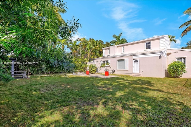 back of house featuring a patio and a lawn