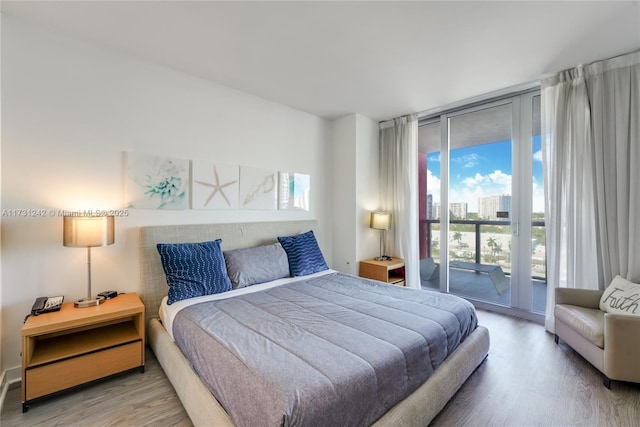 bedroom with hardwood / wood-style flooring, access to outside, and floor to ceiling windows