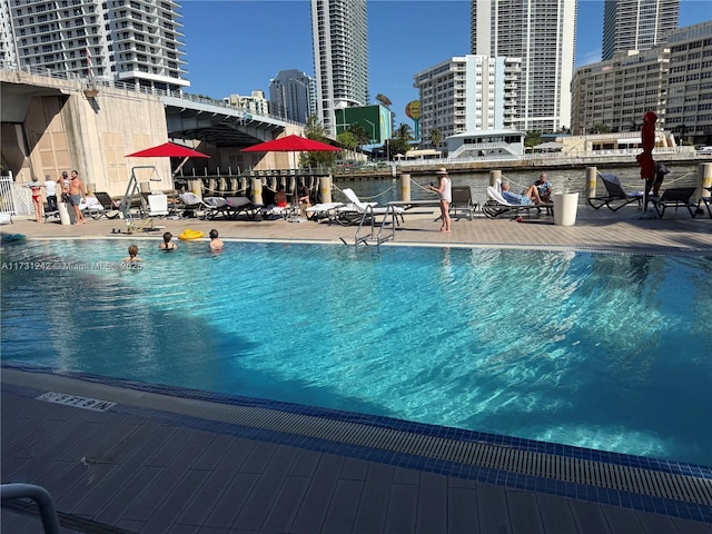 view of swimming pool featuring a patio and a water view