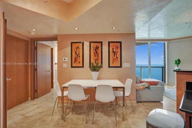 dining area with a water view and expansive windows