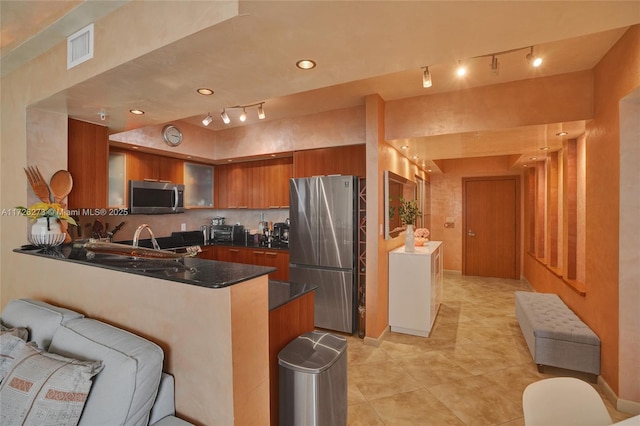 kitchen with stainless steel appliances, sink, light tile patterned floors, and kitchen peninsula