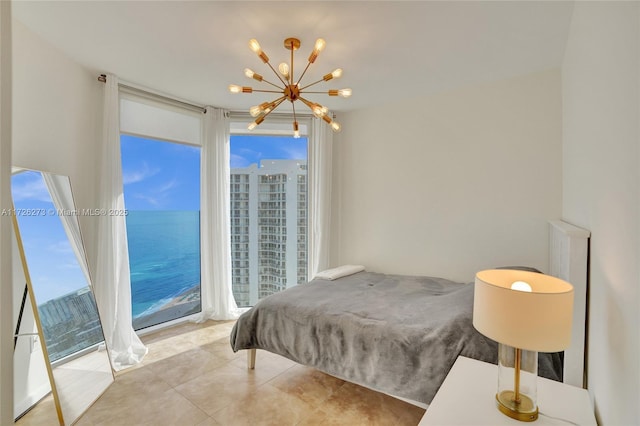 bedroom with a water view and a chandelier