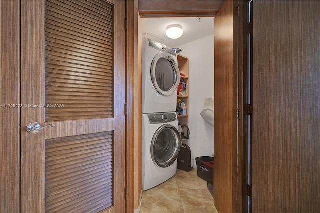 laundry room with light tile patterned flooring and stacked washer / drying machine