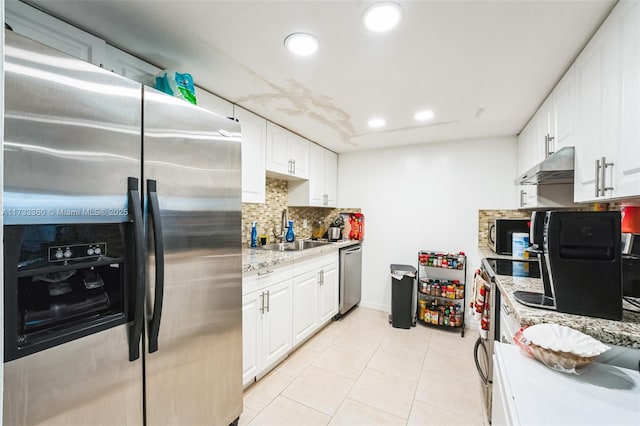 kitchen featuring sink, white cabinetry, appliances with stainless steel finishes, light stone countertops, and decorative backsplash