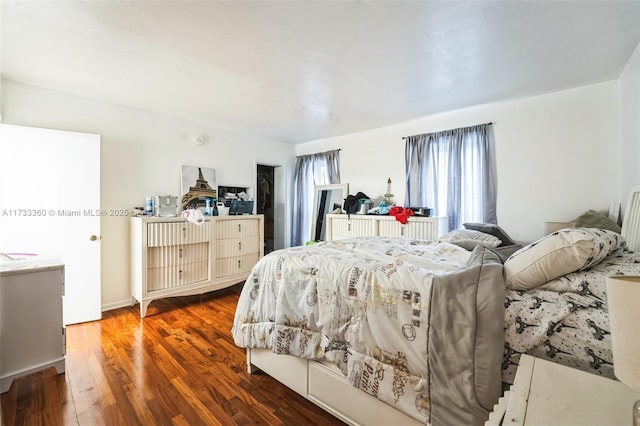 bedroom featuring multiple windows, radiator heating unit, and dark hardwood / wood-style flooring