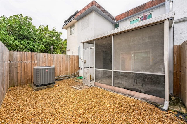 back of house featuring a sunroom and central air condition unit