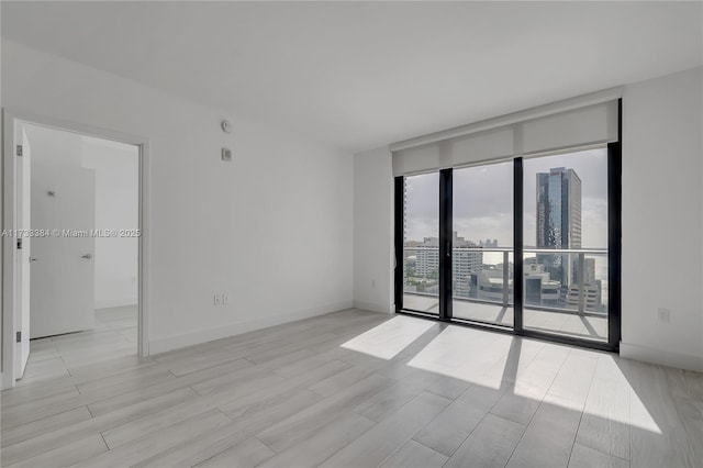 spare room featuring light hardwood / wood-style floors and floor to ceiling windows