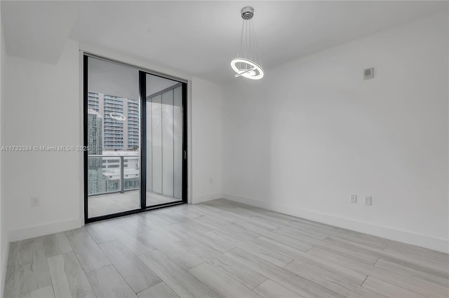 unfurnished room with light hardwood / wood-style flooring and expansive windows