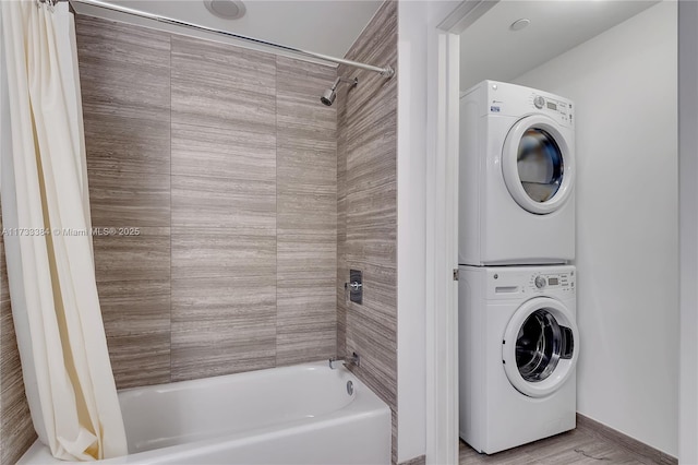 washroom with stacked washer and clothes dryer and light hardwood / wood-style flooring