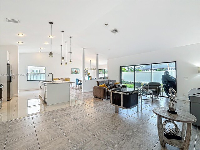 tiled living room with vaulted ceiling and sink