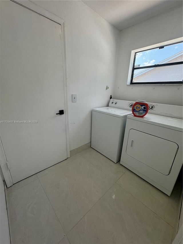 laundry room featuring separate washer and dryer and light tile patterned floors