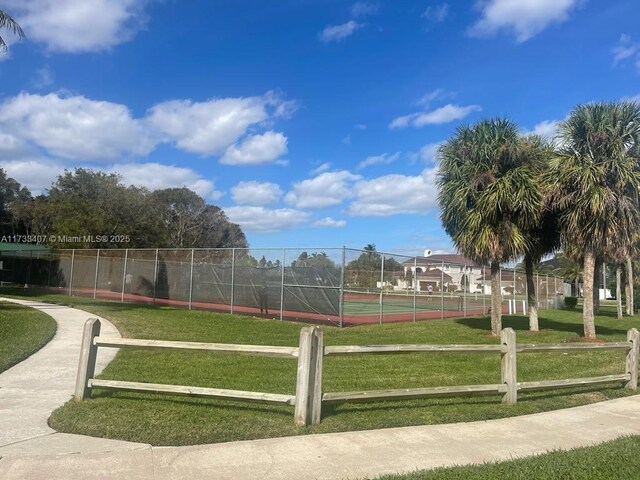 surrounding community featuring a yard and tennis court