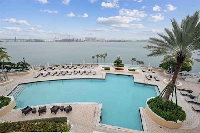 view of swimming pool featuring a water view and a patio area