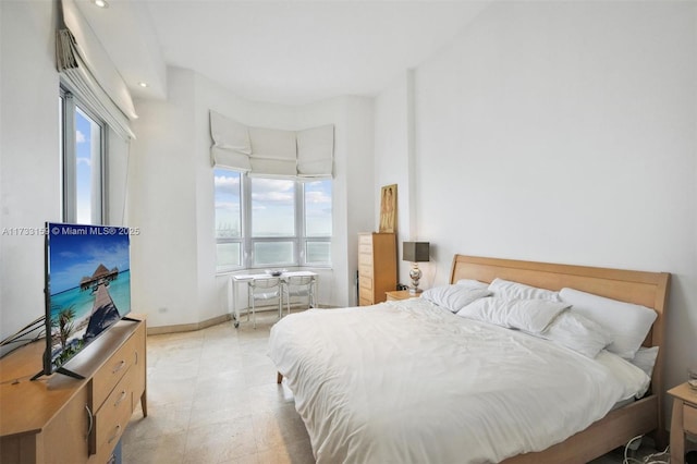 bedroom featuring a water view and multiple windows