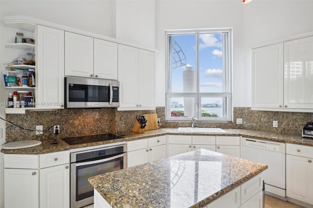 kitchen featuring dark stone countertops, sink, white cabinets, and appliances with stainless steel finishes