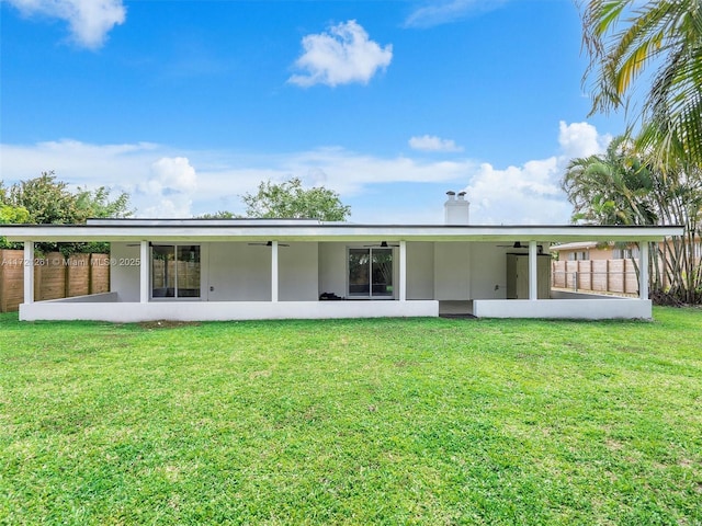 rear view of house featuring a lawn